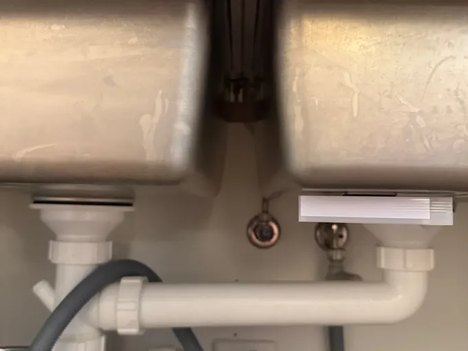 Double kitchen sink waste pipes and dishwasher hose under the bench in Mascot