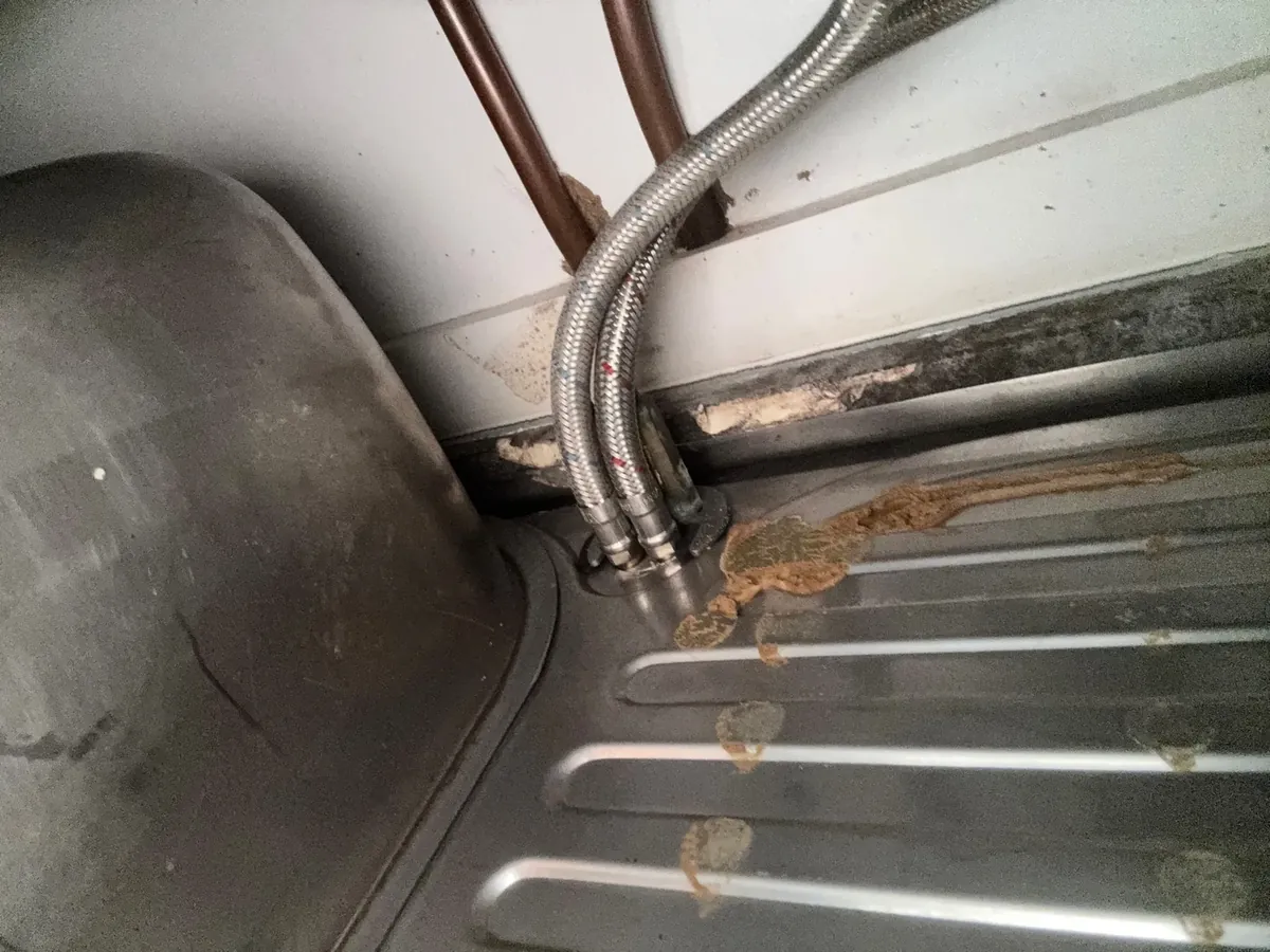 Braided hoses and pipe tails under a kitchen sink in Lakemba