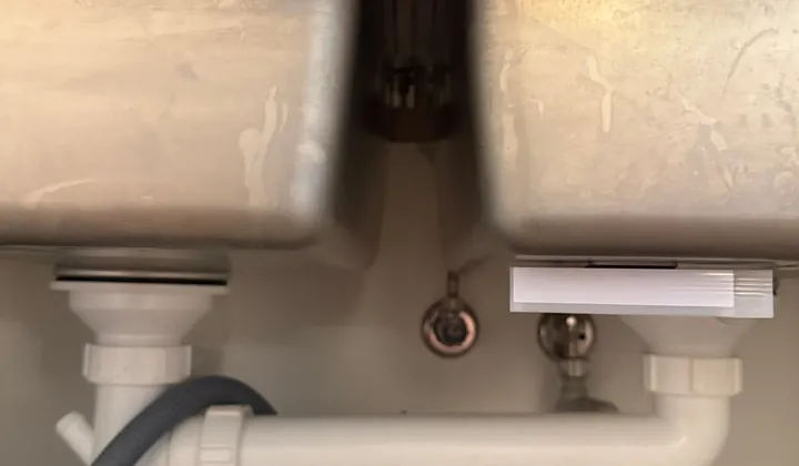 Double kitchen sink waste pipes and dishwasher hose under the bench in Mascot