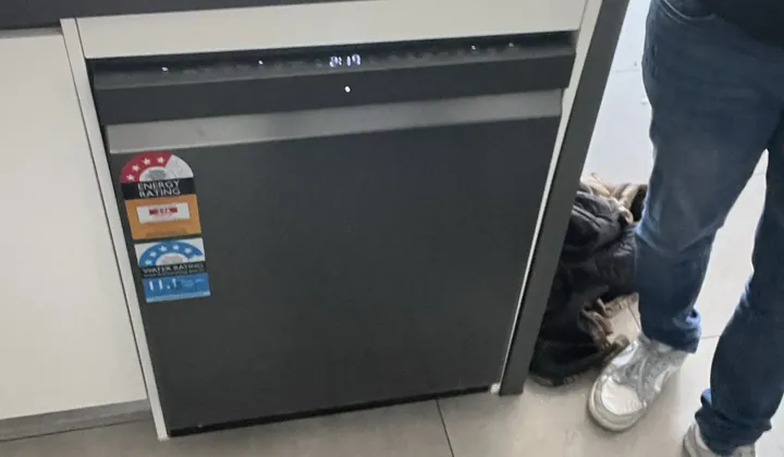 New black dishwasher running under a stone island bench after installation in Bexley