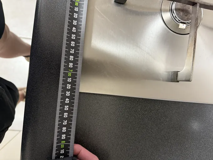 Measuring the benchtop beside a stainless gas cooktop in Bankstown