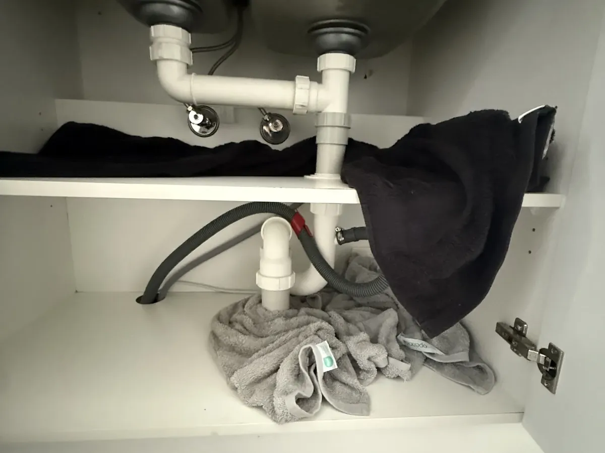 Dishwasher drain hose connected to the trap under a double sink in Spring Farm