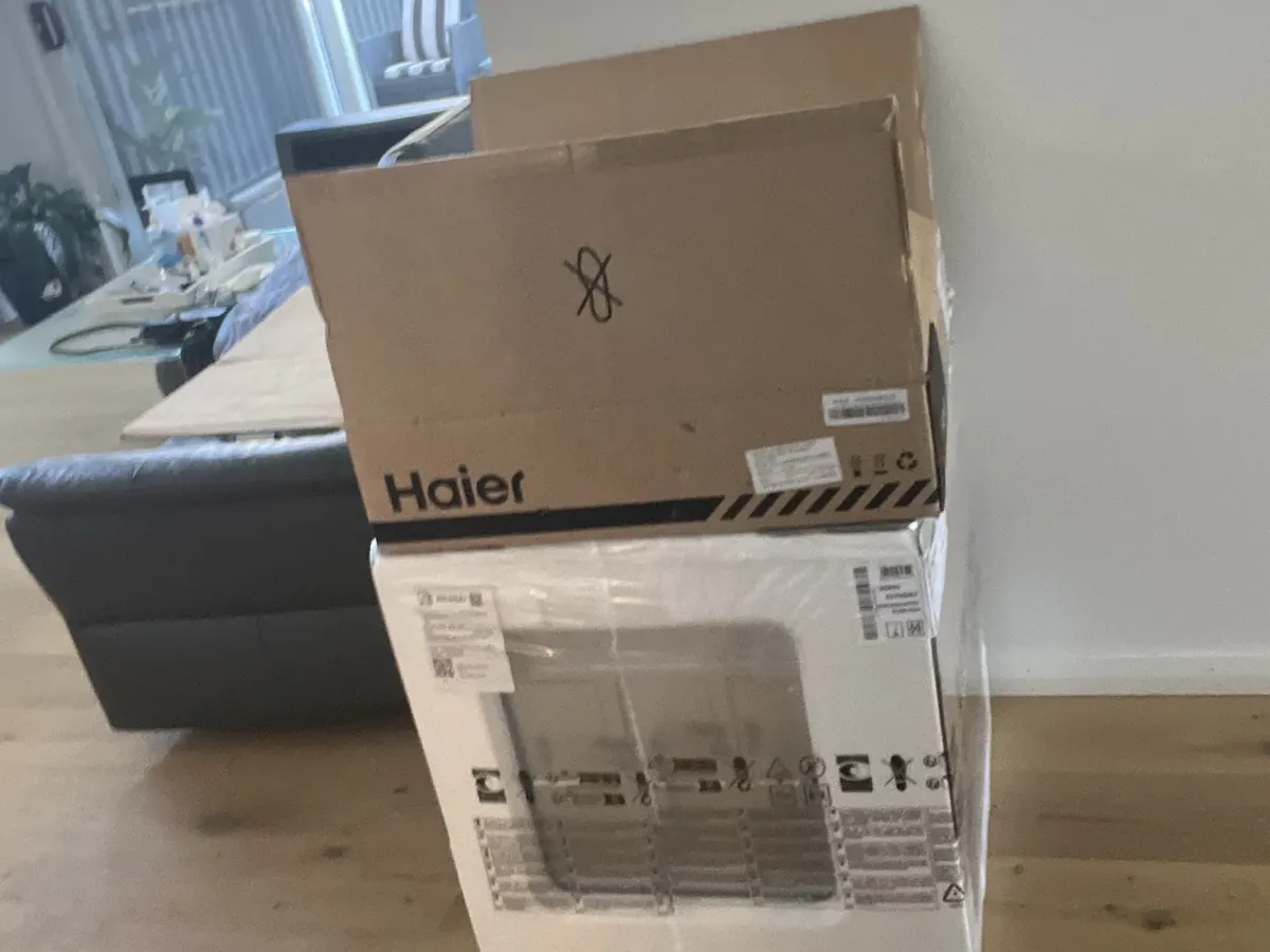 New kitchen appliances still in their boxes, stacked in a living room in Spring Farm