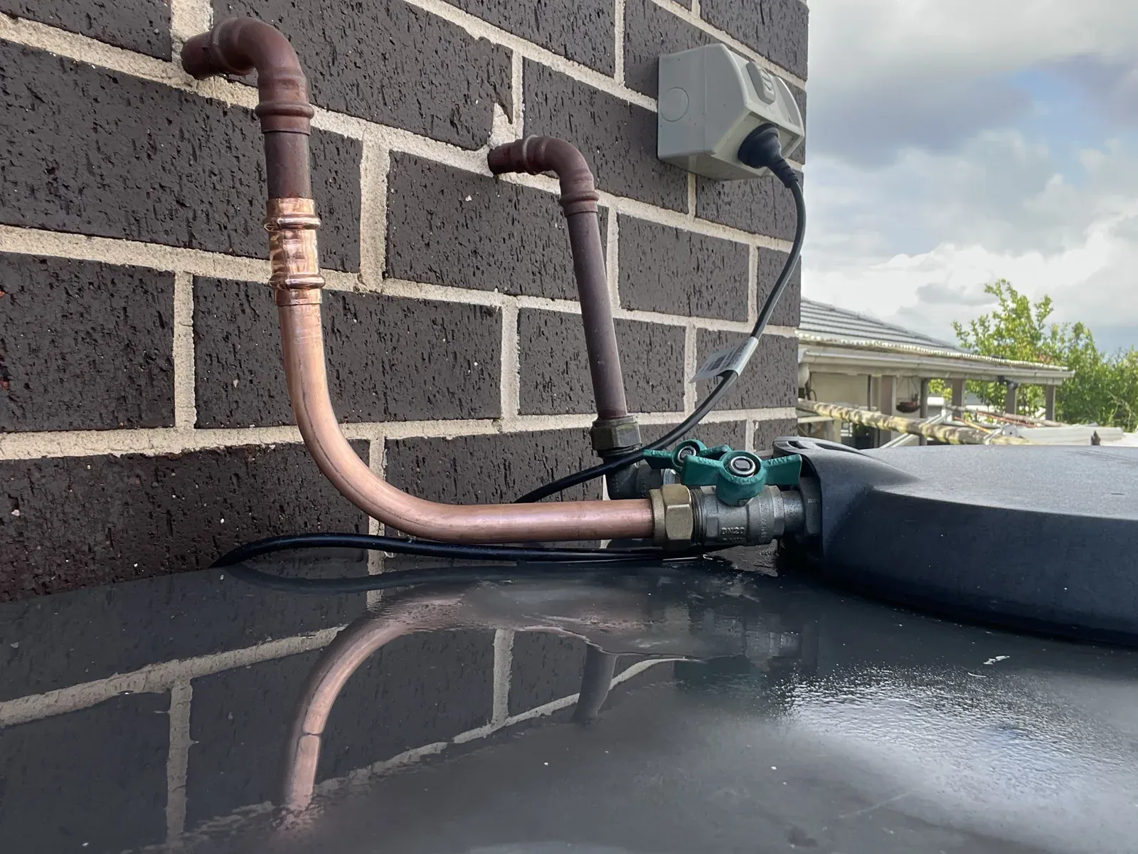 Copper water pipe repaired with new press fittings beside a rainwater tank in Greenacre