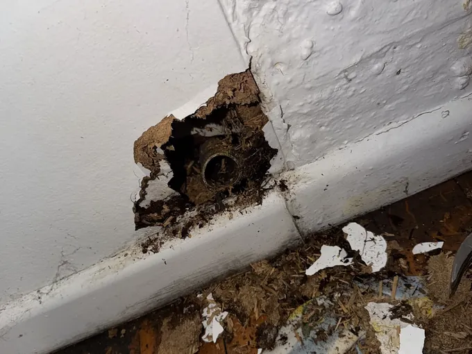 Wall opened at skirting level to reach a pipe in Glebe