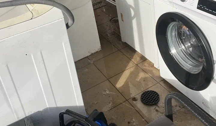 Laundry floor streaked with dirty water around the floor waste, beside the washing machines, in Green Valley