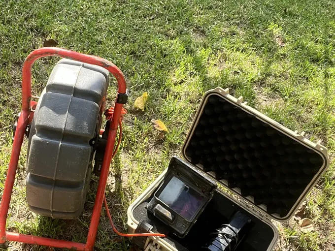 Drain camera reel and monitor case set up on a lawn in Randwick