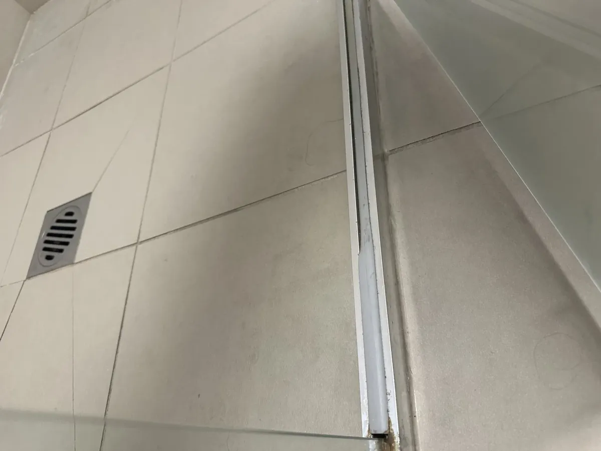 Shower screen channel and floor waste on the tiled floor of a bathroom in Warwick Farm