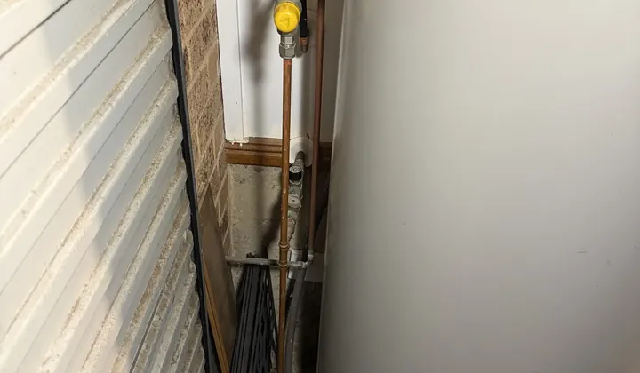 Valves and a braided hose on the water connections of an electric hot water system in Illawong