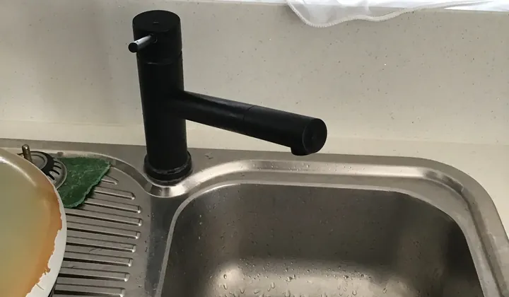 Black kitchen mixer tap on a stainless steel sink in Mount Druitt