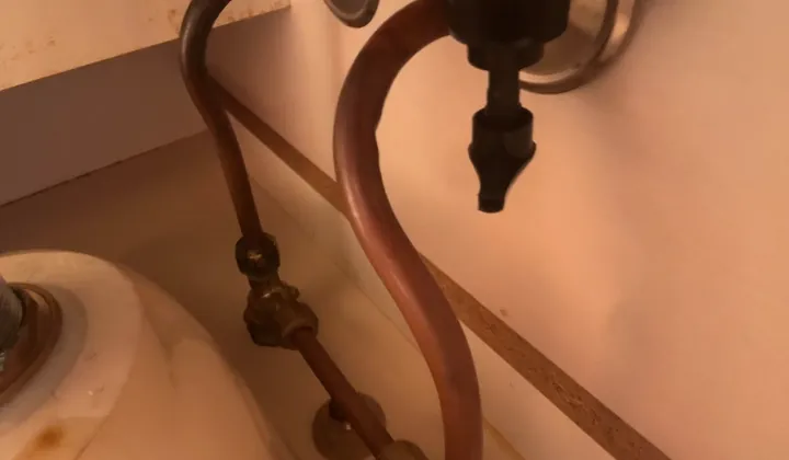 Copper water pipes and valves under a bathroom basin in Kingsgrove