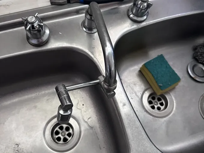 Kitchen sink taps with a handle removed and pliers on the bench in Doonside