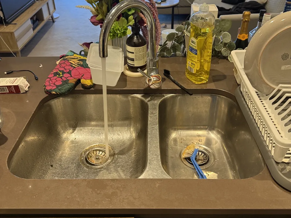 Kitchen tap running with a thin stream of water in a Parramatta apartment
