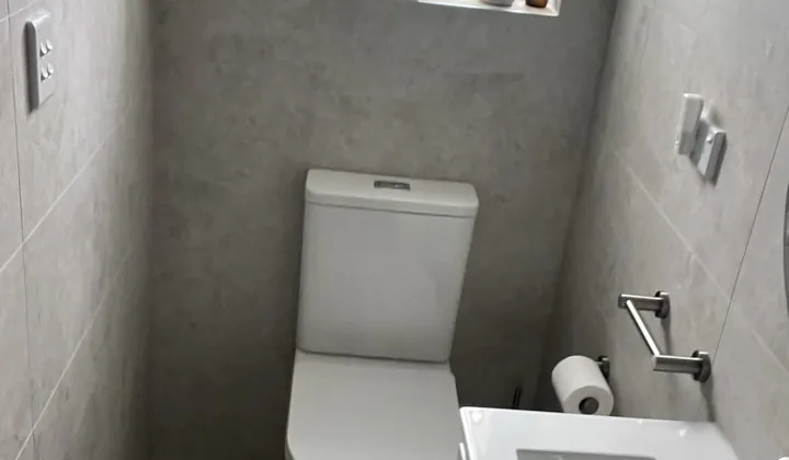 Small renovated bathroom in Padstow with a wall-hung basin, back-to-wall toilet and large-format grey tiles