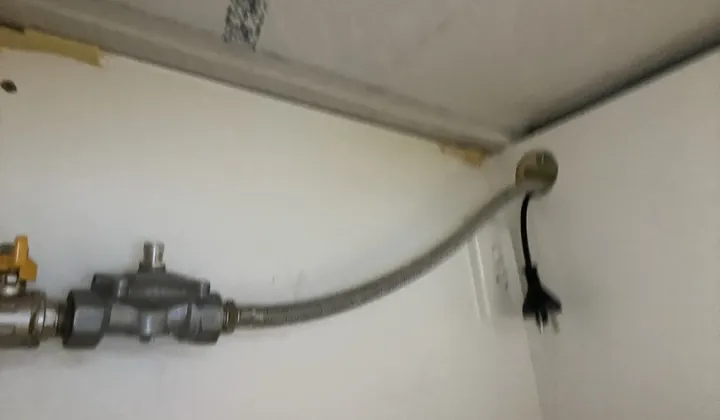 Gas isolation valve, regulator and braided hose running up through a bench cupboard in Waterloo