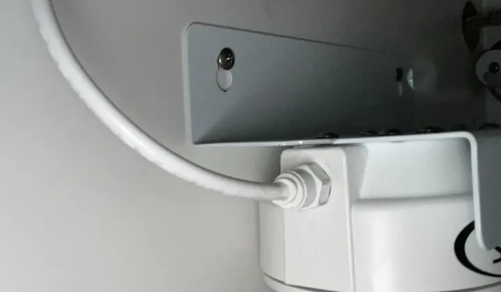 Water filter housing on a steel bracket with a white water line, under a kitchen sink in Whalan
