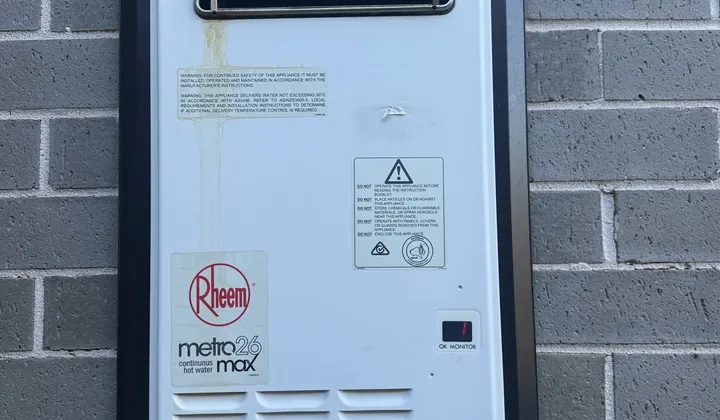 Rheem continuous flow gas hot water unit in a wall recess box on grey brick in Denham Court