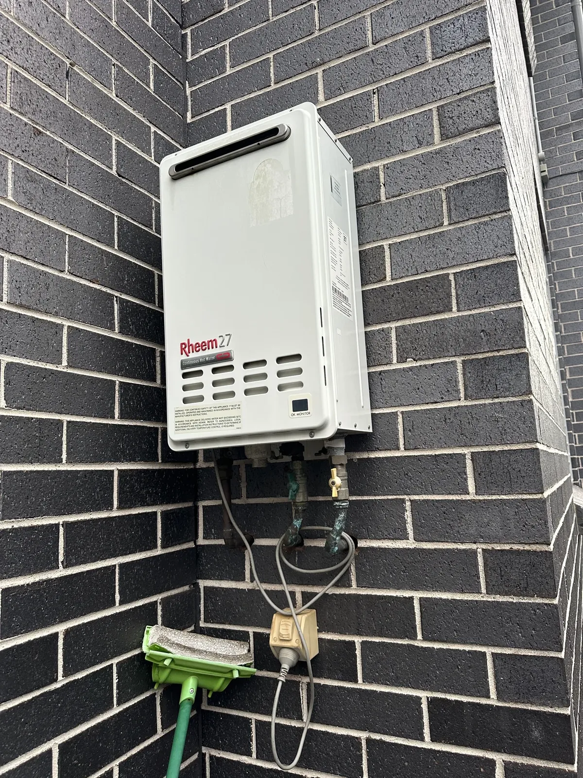 Rheem Hot Water Sydney - Rheem 27 continuous flow gas hot water unit on an outside brick wall