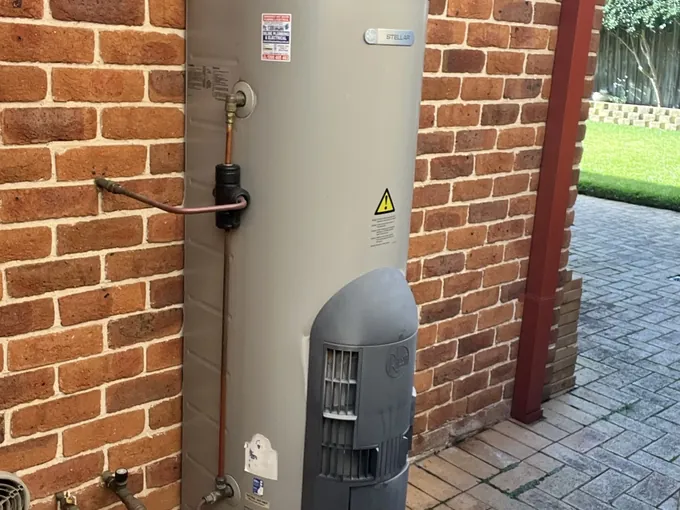 Rheem Stellar gas storage hot water system against a brick wall