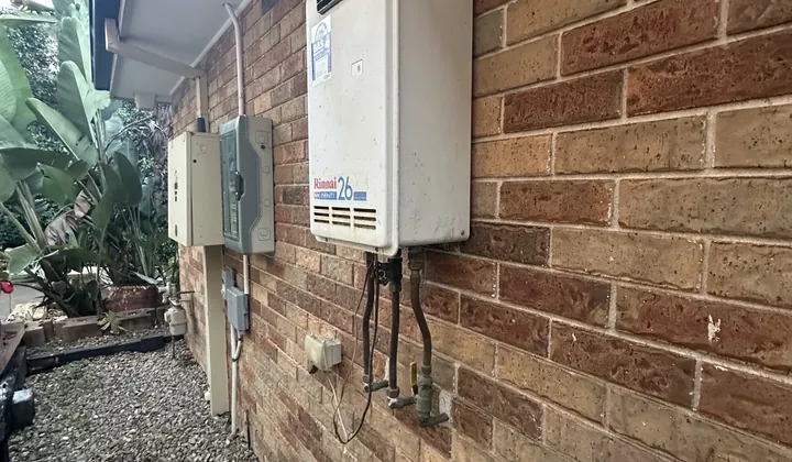 Rinnai Infinity 26 continuous flow gas hot water unit on a brick wall