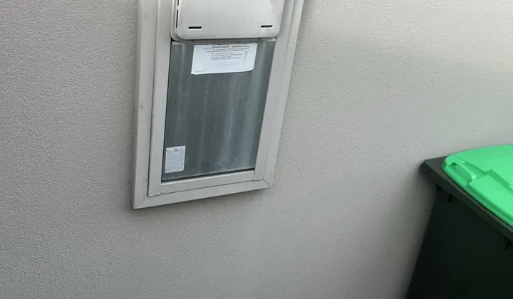 Continuous flow gas hot water unit fitted in a recess box on a rendered wall in Kellyville