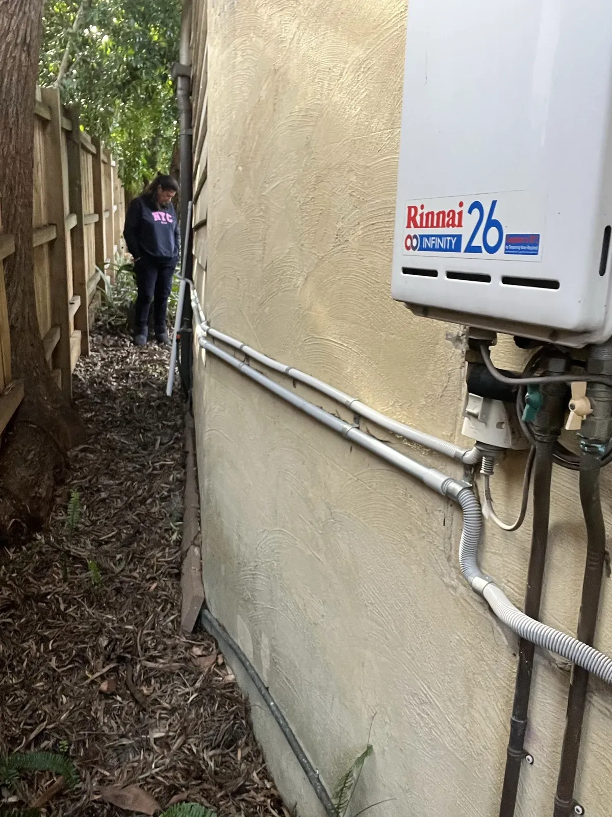 Rinnai Hot Water Sydney - Rinnai Infinity 26 continuous flow unit mounted on a rendered side wall in Hunters Hill