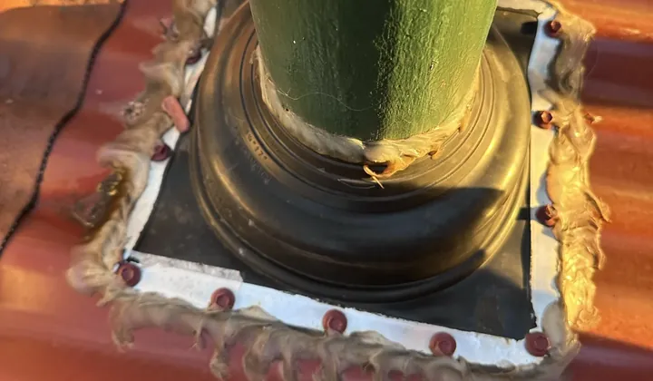 Resealed rubber flashing boot around a green pipe on a corrugated iron roof in Greenacre