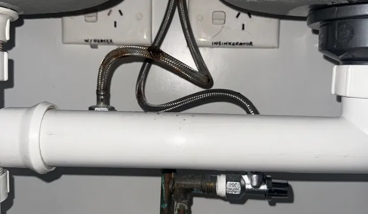 Rusted braided flexi hoses under a double kitchen sink