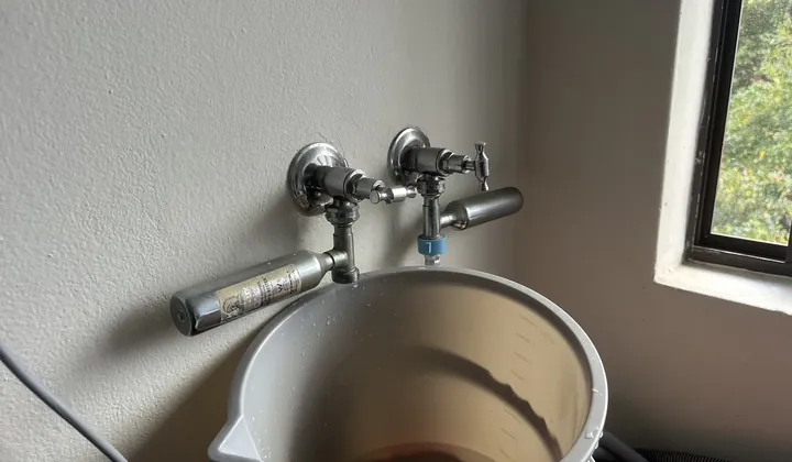 Leaking laundry taps dripping into a bucket