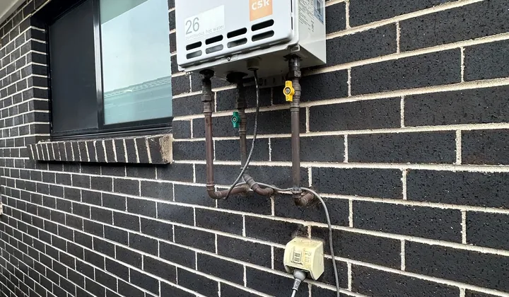 Gas continuous flow hot water unit mounted on a brick wall