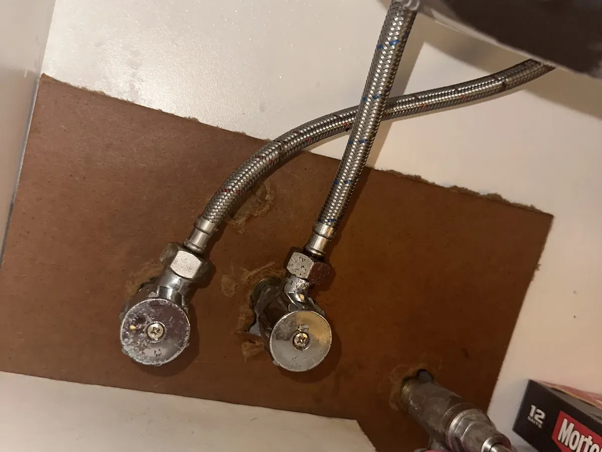 Isolation taps and braided hoses under a sink