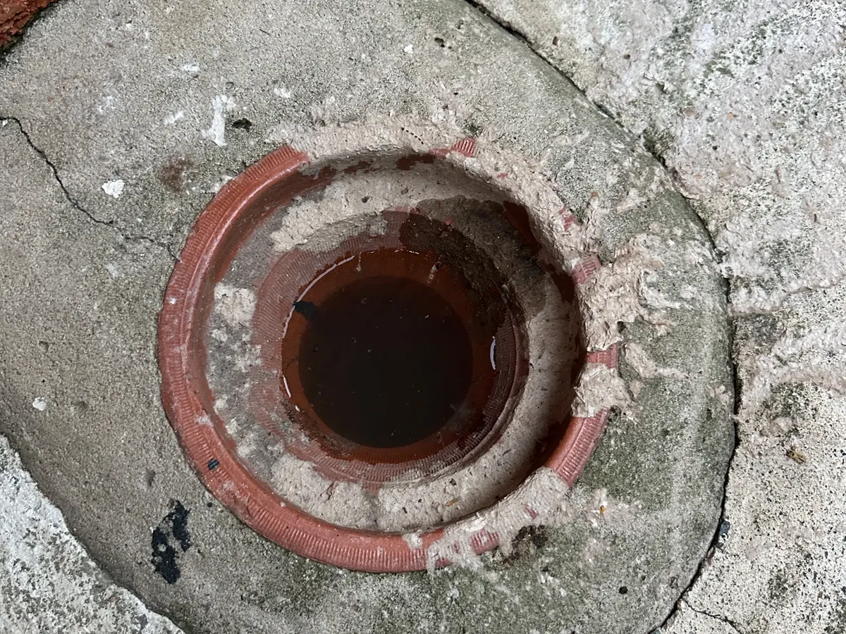 Overflow relief gully with the grate off, ringed with sewage residue, in Greystanes