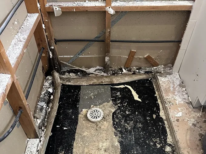 Small bathroom shower stripped back to the frame and old shower base