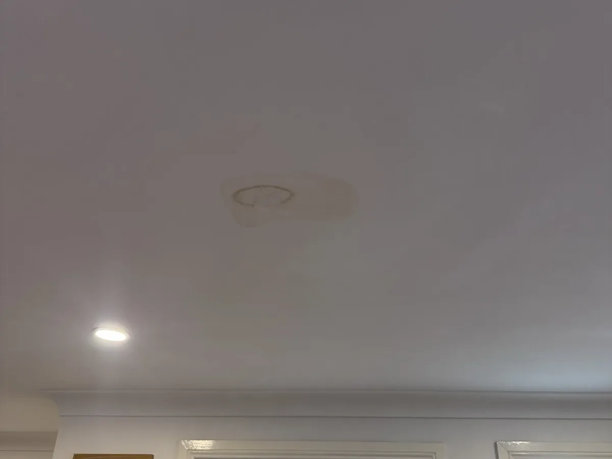 Water stain on a ceiling beneath an upstairs bathroom