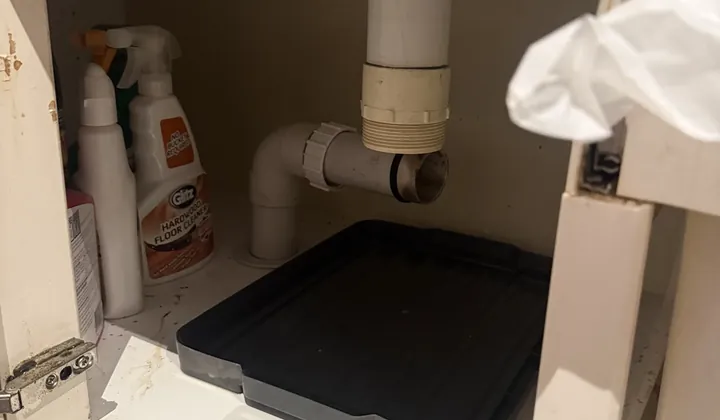 Sink waste pipe with the trap taken off under a cupboard in Erskineville