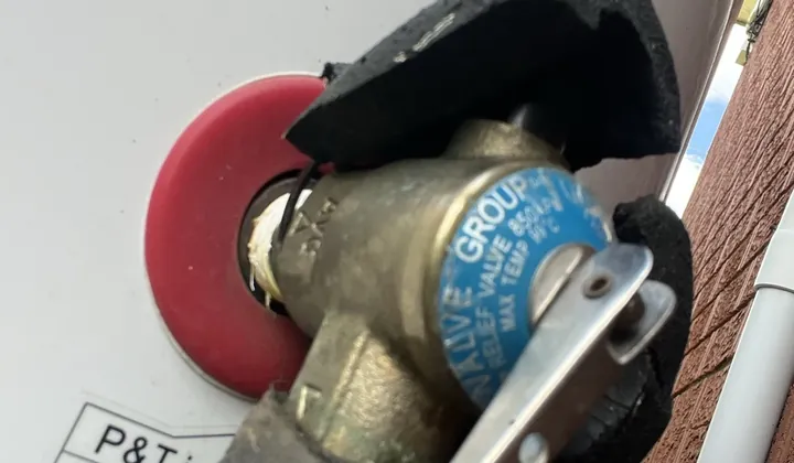 Temperature and pressure relief valve on a hot water tank with lagging around the pipe