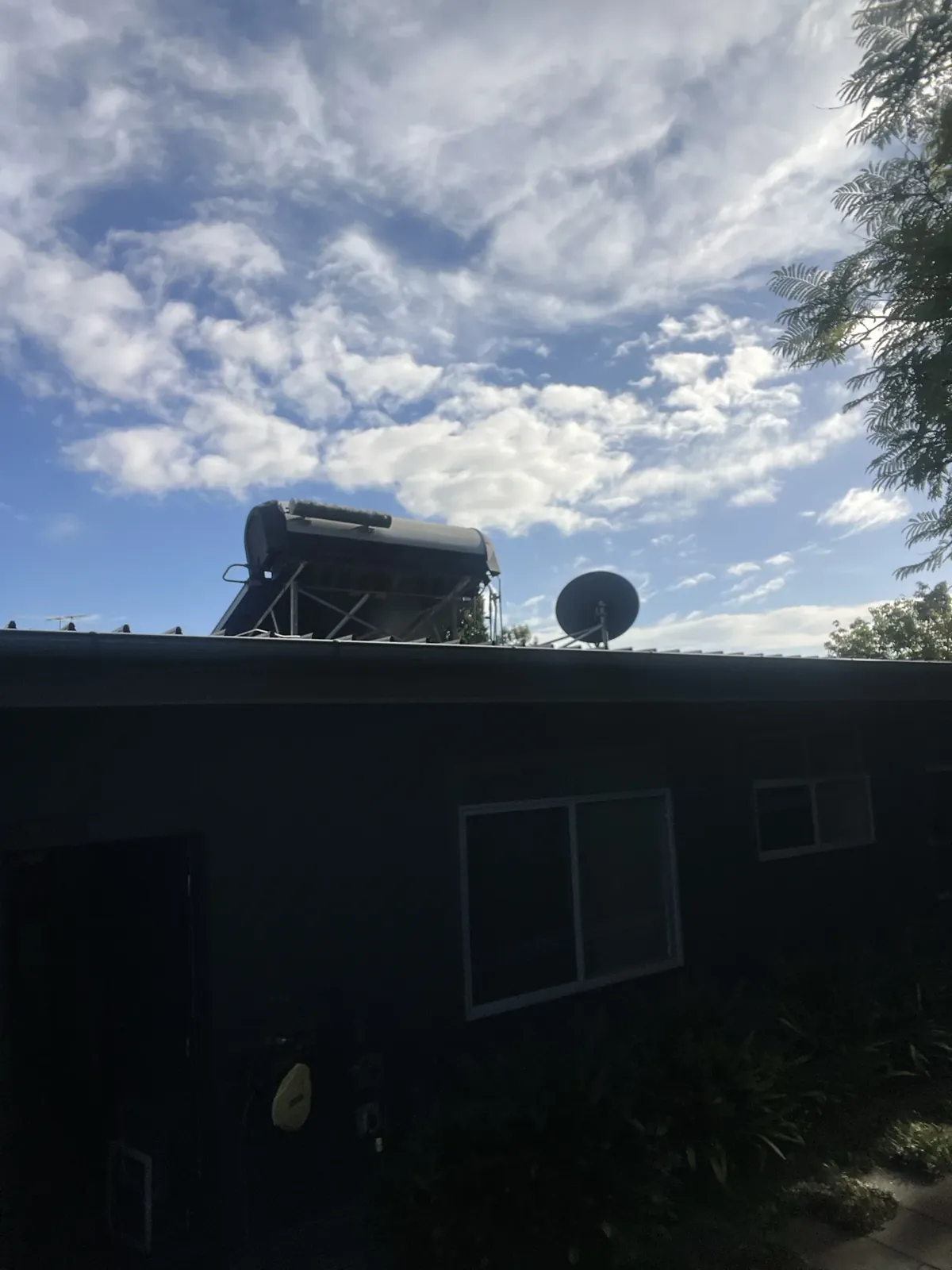 Solahart Hot Water Sydney - Solar hot water tank and frame on a roof beside a satellite dish in South Turramurra