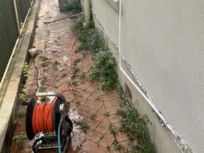 Jetter hose reel and hose run along a wet side path to the downpipe in Earlwood