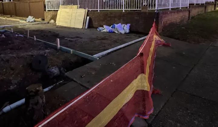 Front yard excavation for a new storm water line to the street, fenced off with safety mesh in Jannali