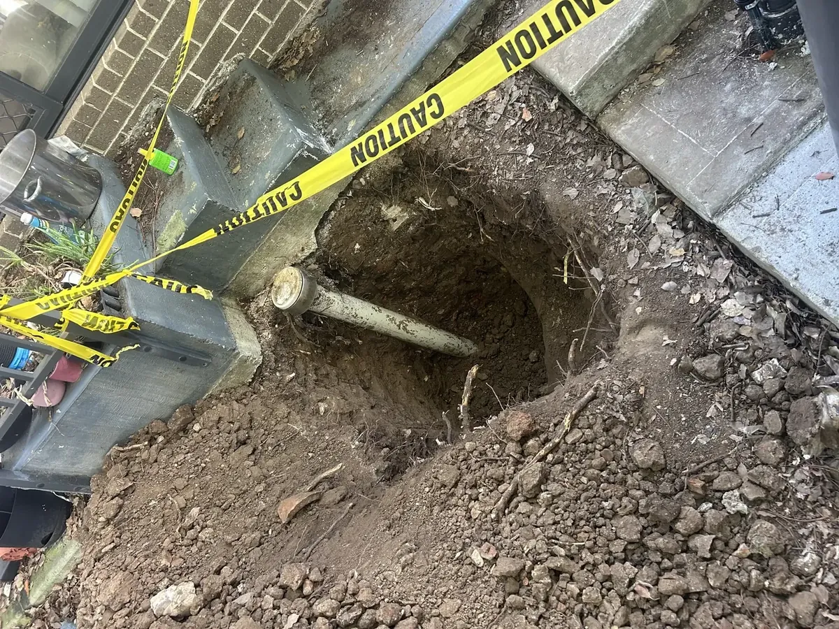 Excavation around a storm water pipe beside a front step, taped off with caution tape in Mount Druitt