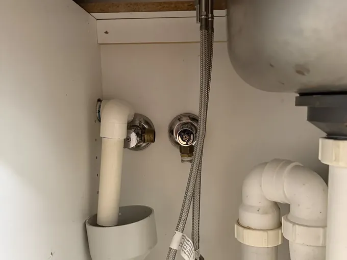 Braided mixer hose and two isolation valves under a kitchen sink in Bella Vista