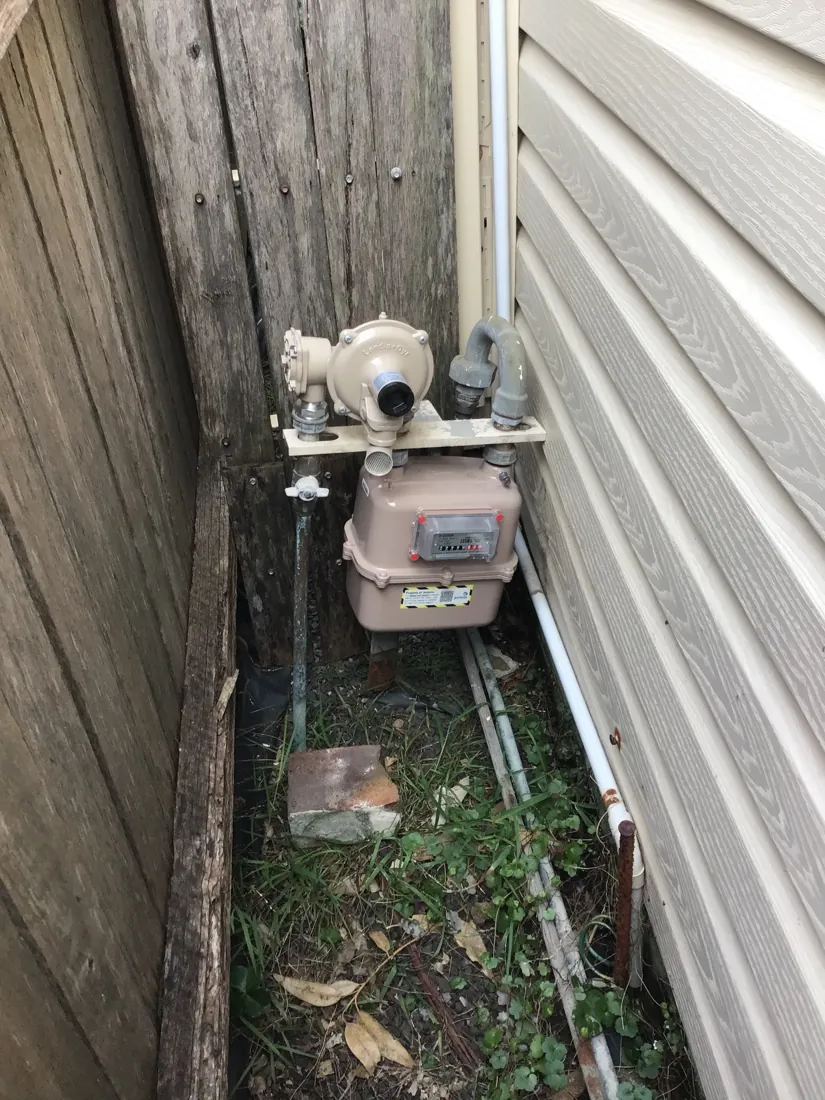 Gas meter and service line in a side passage checked by a Mr Splash gas plumber in Tempe