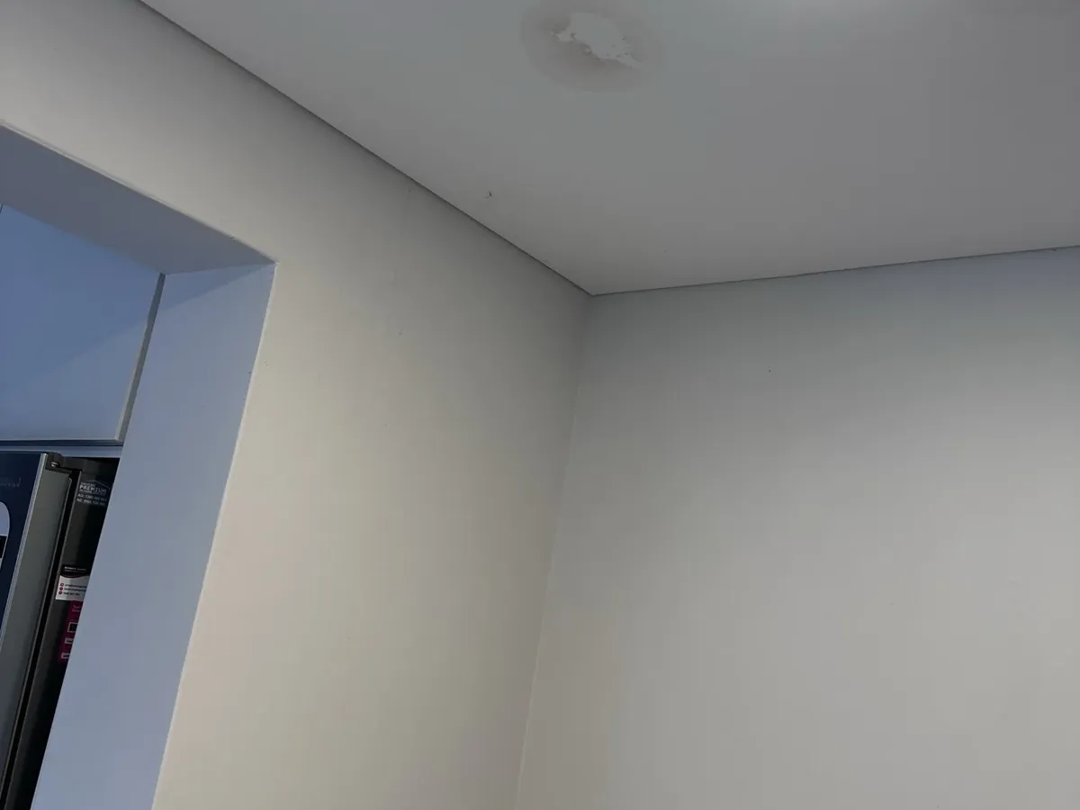 Water stain on a ceiling below a leaking hot water system in an apartment