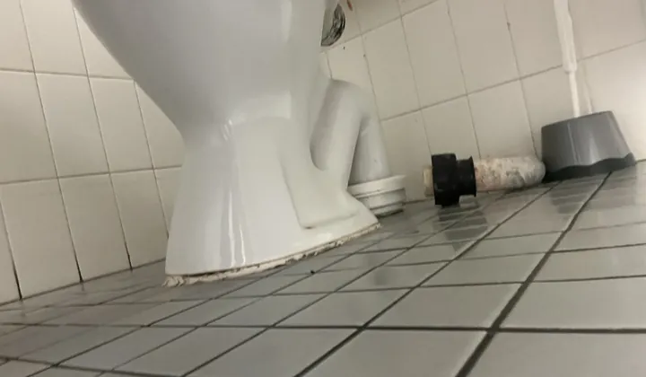Toilet pan base with worn bedding and an old pan connector on the tiled floor in Liverpool