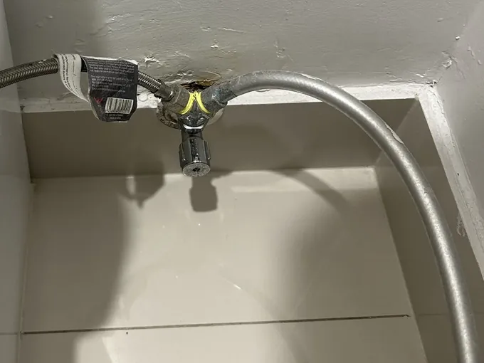 Stop tap on the wall behind a toilet with a new braided hose fitted in The Ponds