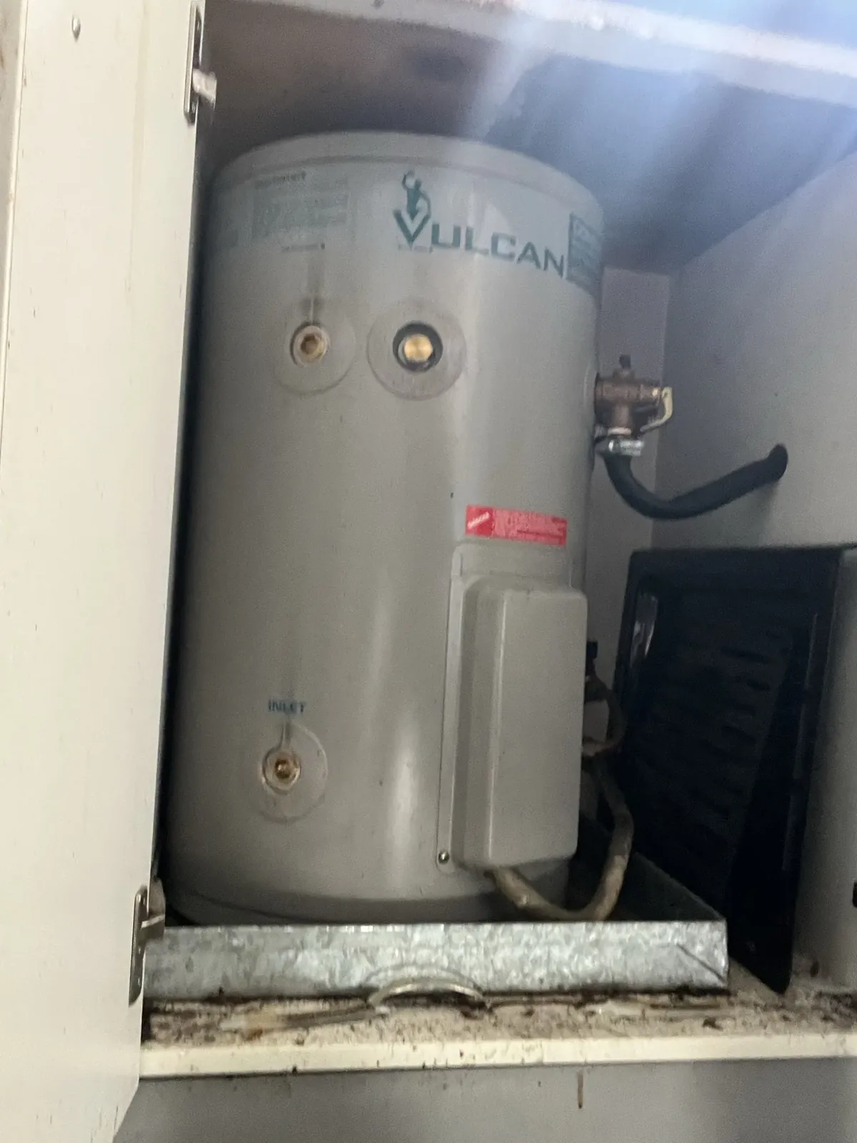 Vulcan Hot Water Sydney - Vulcan electric storage tank and its relief valve inside a cupboard in Dulwich Hill
