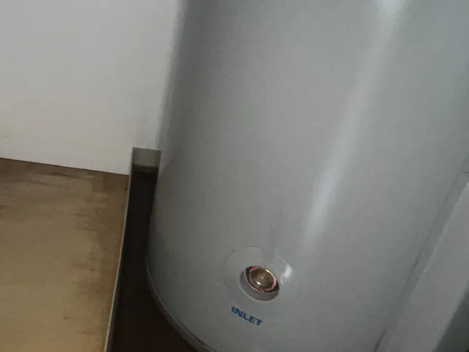 Electric hot water tank standing in a safe tray inside a cupboard in Randwick