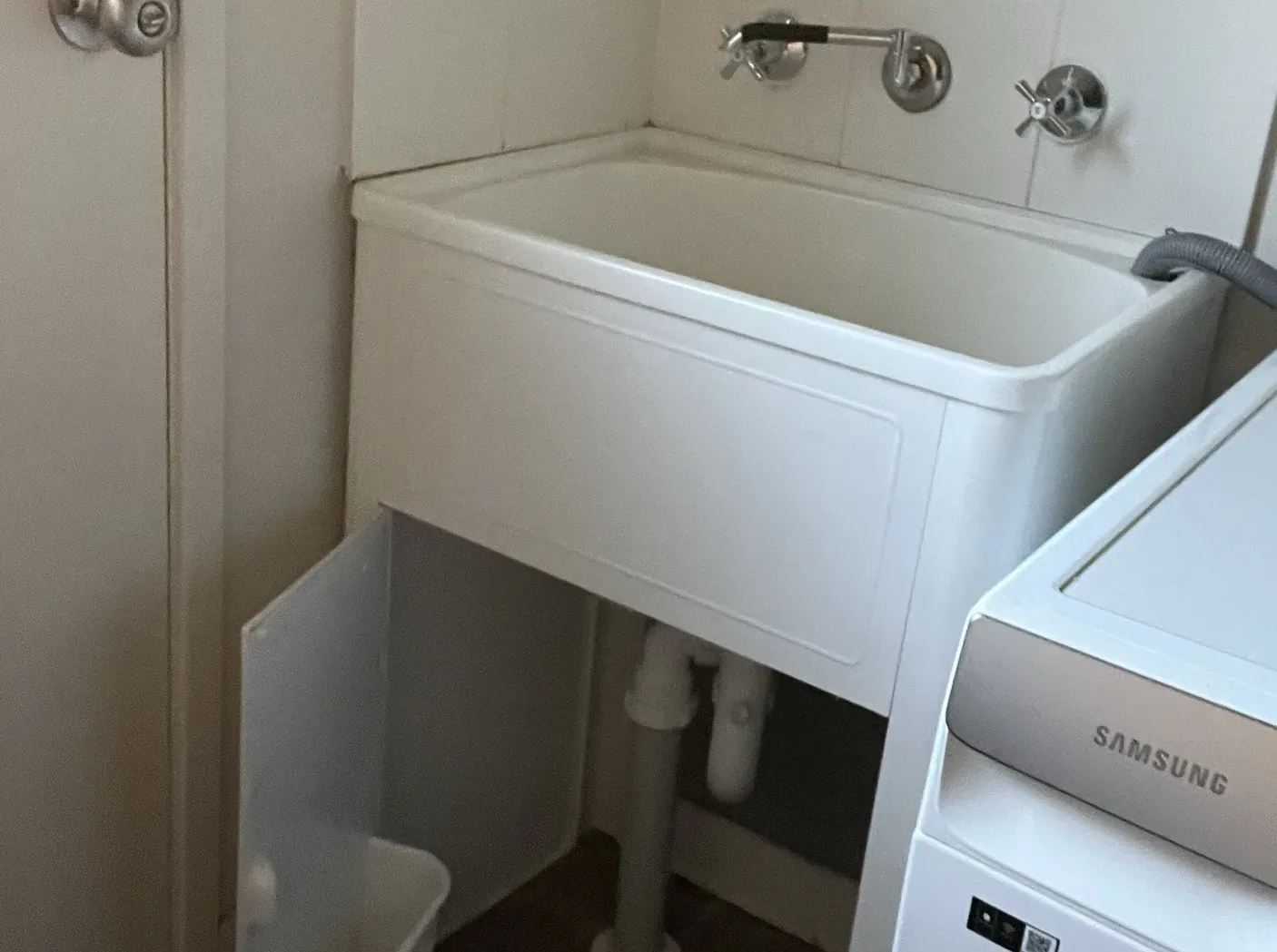 New laundry tub with wall taps beside a front loader washing machine in The Ponds