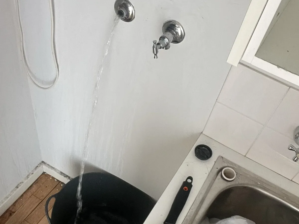 Water running from a laundry tap to check it, beside the tub in Stanmore