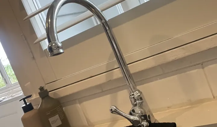 Chrome gooseneck tap with a side lever on a stainless steel kitchen sink in Collaroy Plateau